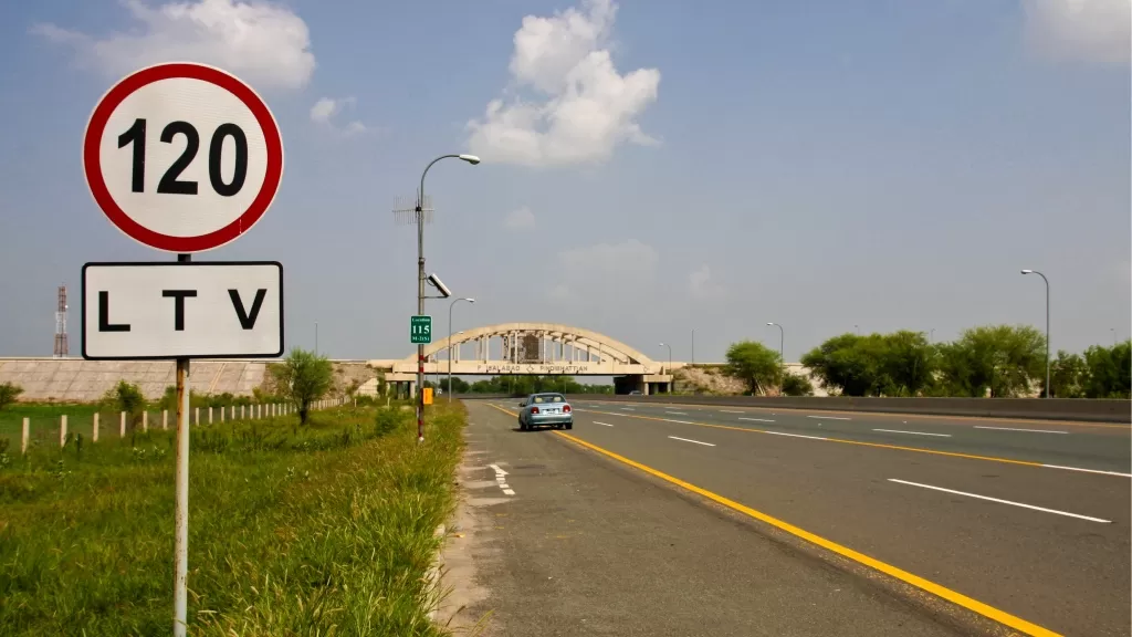 Sign showing speed limit on a highway in Pakistan.